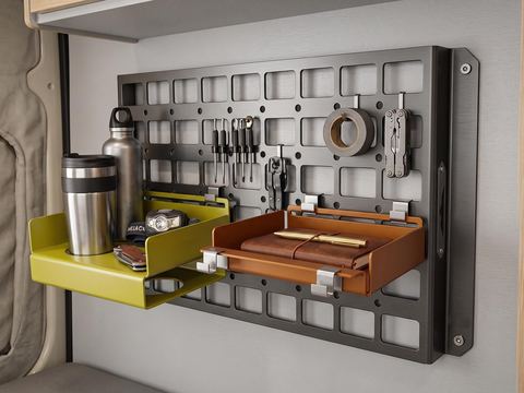 Modular MOLLE panel on a van wall with two fold-down trays and tools